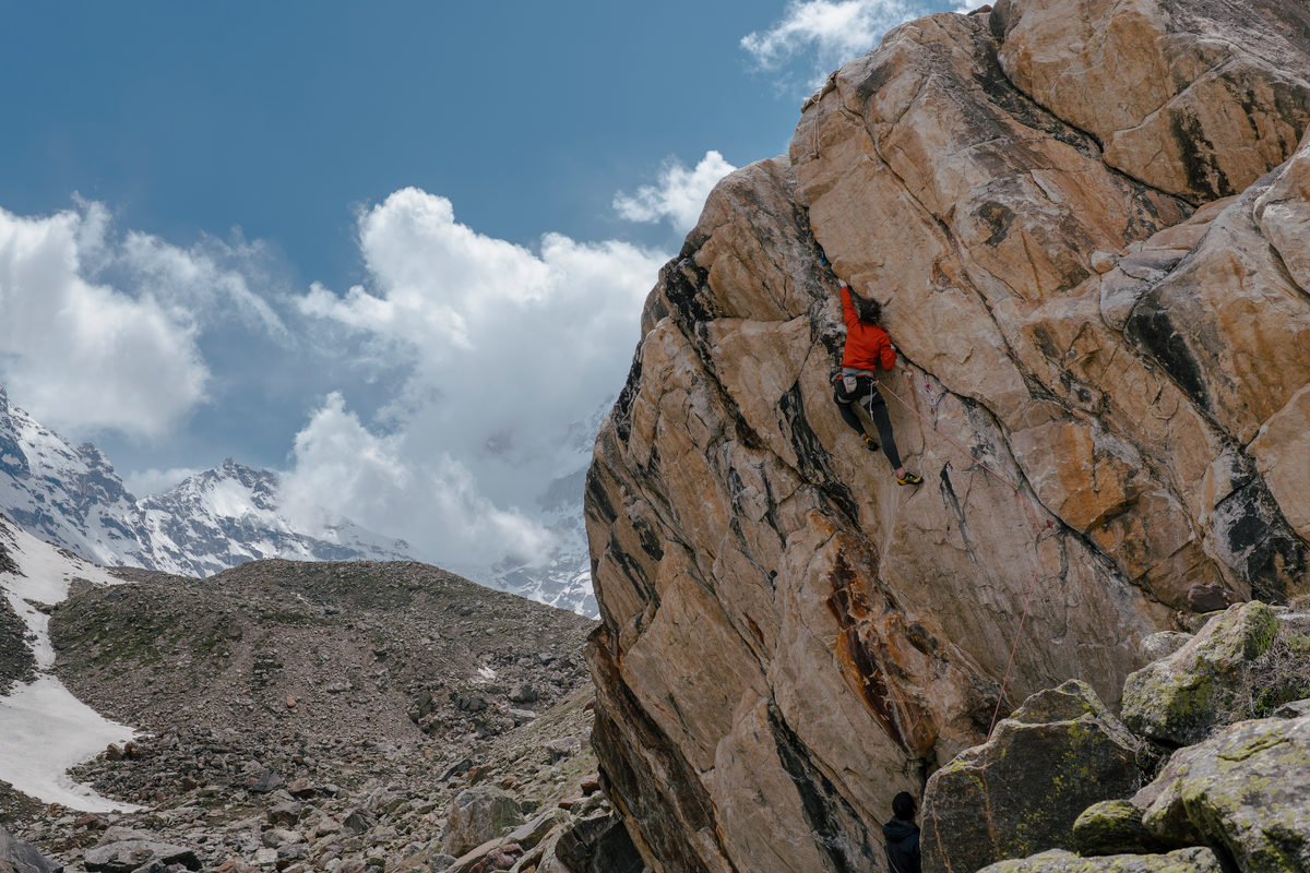 A rock climber climbing a route in Surya Kund basecamp, India