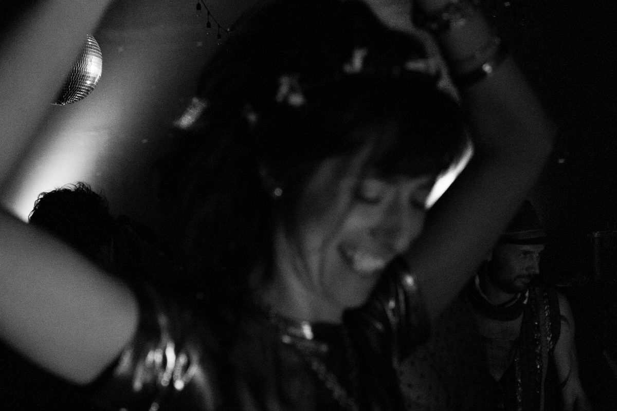 Black and white: a dancer caught mid-movement under low light of a disco ball