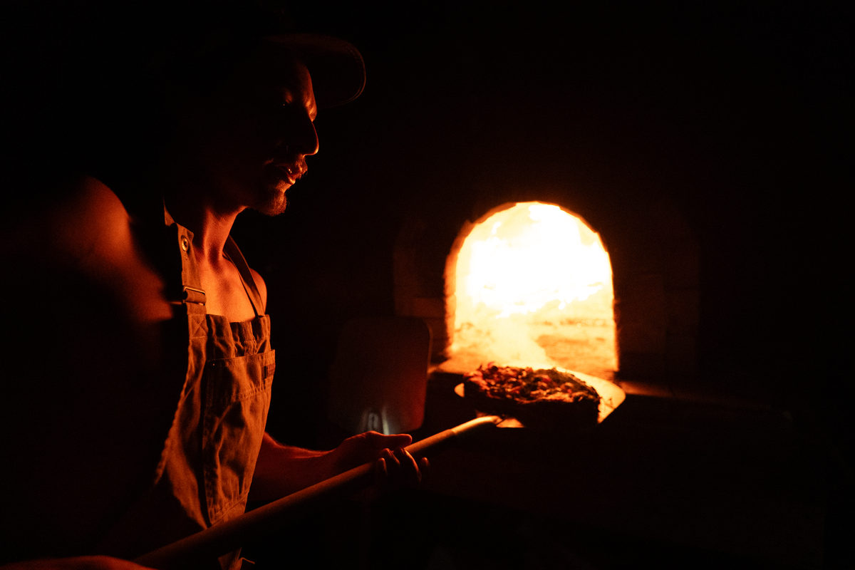 pulling a pizza from a pizza oven, tuolumne meadows, california