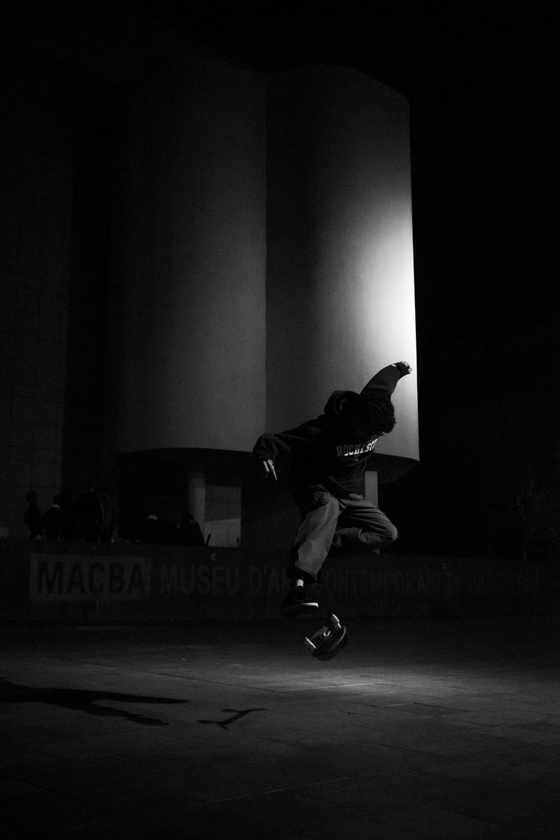 Skateboarder doing a kickflip in front of the MACBA museum, barcelona spain